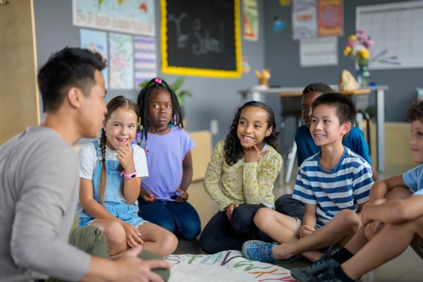 Teacher engaging students in a classroom discussion with BE THE VERB! cards